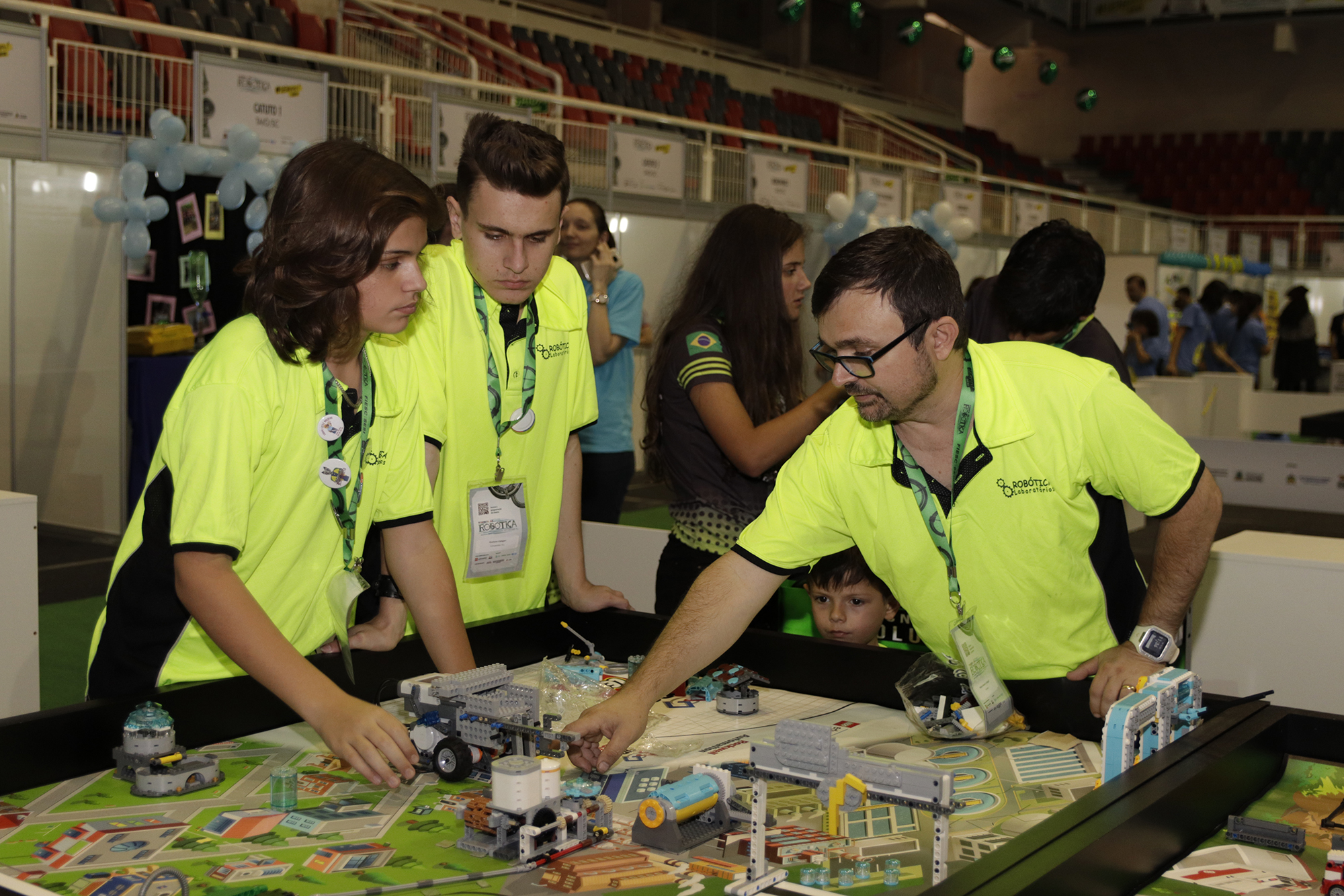 Arthur (e) e Gustavo ajustam detalhes do robô para